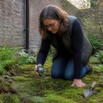 A woman checking moisture levels in a moss garden using a moisture meter